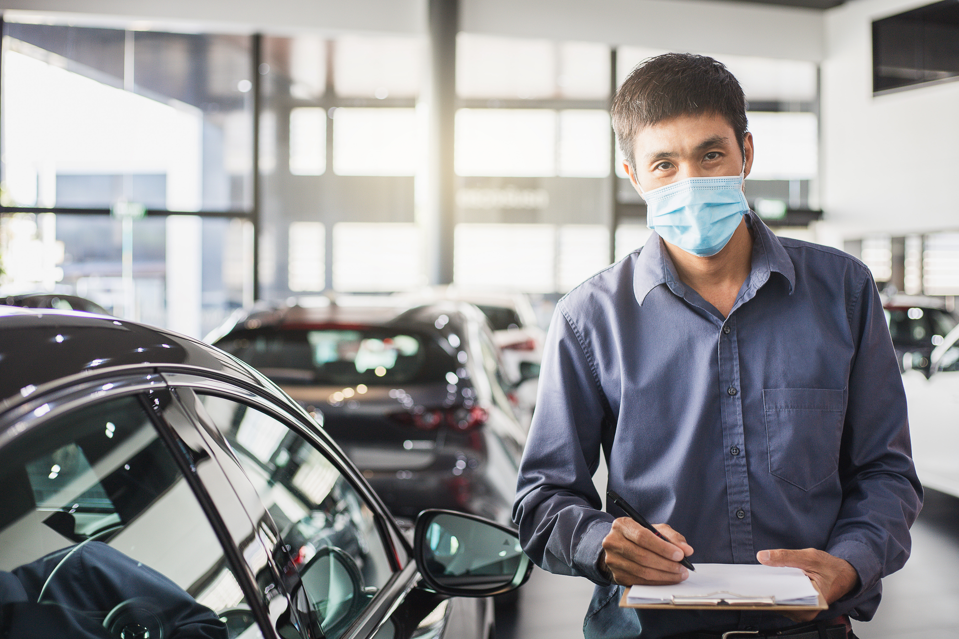 Inspector in auto shop with clipboard