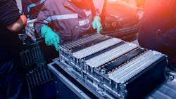 An EV technician servicing a high voltage battery. An EV technician servicing a high voltage battery.
