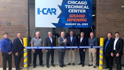 I-CAR&rsquo;s Board of Directors Chair Kyle Thompson (center) is shown ready to cut the ribbon at the main entrance to the 48,000-square-foot facility. He is flanked by members of I-CAR&rsquo;s leadership, including CEO &amp; President John Van Alstyne (fourth from right). From l. are Mike Mertes, Tom Marek, James Busam, Jeff Peevy, Thompson, Tim O&rsquo;Day, Van Alstyne, Jon Petrillo, Bud Center, and Dirk Fuchs.