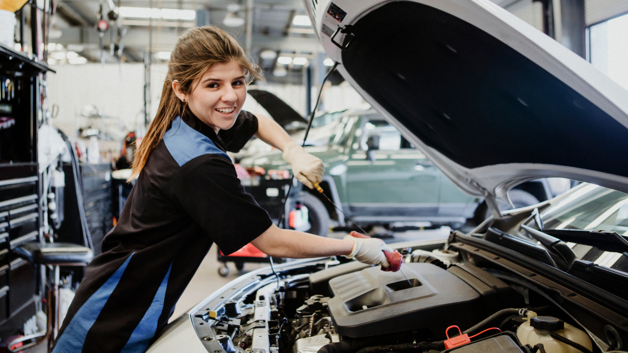 Female tech working on a car