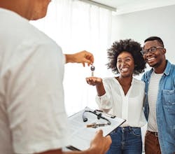 An employee handing customers the keys to their car An employee handing customers the keys to their car