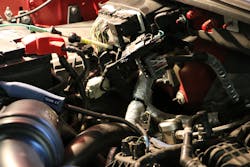 Figure 9- The CKP sensor on a Ford 3.5L EcoBoost is encapsulated in the bellhousing of the transmission behind the bank 2 turbocharger and heat shield. As a result of the inconvenient location of the sensor, I decided to locate the CKP signal wire. Conveniently, this signal wire was located on connector 1951E at the PCM mounted on the passenger side bulkhead. Simply removing tape, locating the terminal location, and probing the signal feed wire provided convenient access to the CKP signal for testing. Figure 9- The CKP sensor on a Ford 3.5L EcoBoost is encapsulated in the bellhousing of the transmission behind the bank 2 turbocharger and heat shield. As a result of the inconvenient location of the sensor, I decided to locate the CKP signal wire. Conveniently, this signal wire was located on connector 1951E at the PCM mounted on the passenger side bulkhead. Simply removing tape, locating the terminal location, and probing the signal feed wire provided convenient access to the CKP signal for testing.