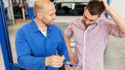 Technician explaining repairs to customer in shop