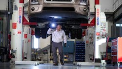 A technician inspects the underbody of a vehicle using a four-post lift, a key component to shop safety. A technician inspects the underbody of a vehicle using a four-post lift, a key component to shop safety.