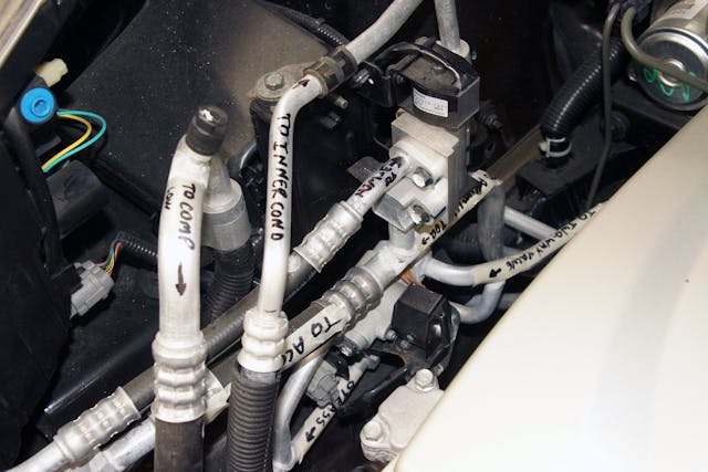 Figure 5 &ndash; The Nissan heat pump system is one of the least complex in production. However, the maze of HVAC lines is convoluted. Depending on the position of the two-way and three-way valves, heating, cooling, and de-icing can be achieved. The lines are labeled to help HVAC students at Pennsylvania College of Technology understand the refrigerant flow.