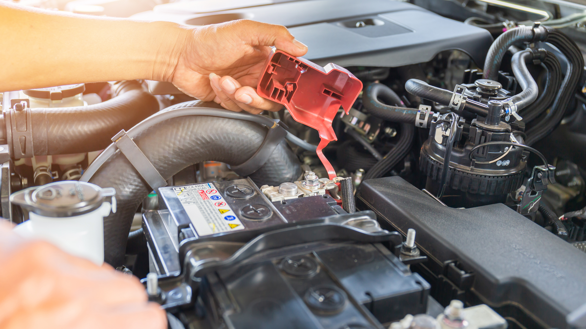 Technician removing battery terminal cover