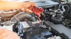 Technician removing battery terminal cover