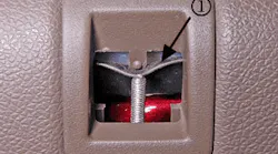 Use a flat-bladed tool to disengage the detent tab.