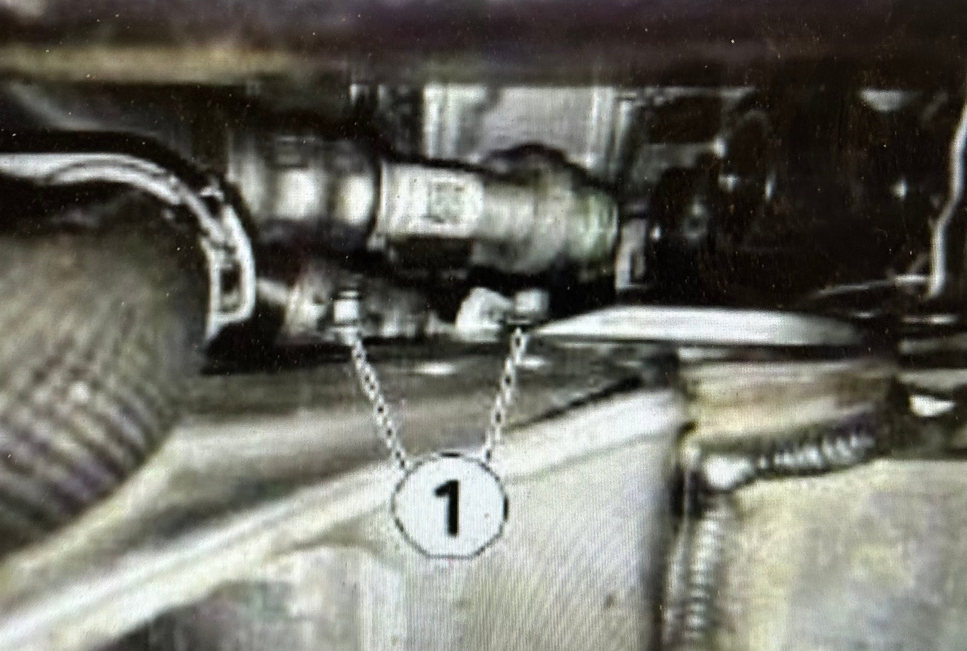 Remove the left front wheel, stiffening plate and steering assembly cover. Disconnect the clamp holding the transmission oil cooler thermostat from the holder.