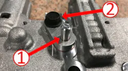 Valve body plug (1) and retaining bolt (2) locations.