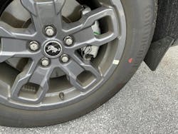 Example of a tire mounted. This tire features only a red dot, with no yellow dot. The wheel features a sticker indicating the wheel low point. The tire is mounted to align the red dot (highest point of radial runout) to this sticker. Example of a tire mounted. This tire features only a red dot, with no yellow dot. The wheel features a sticker indicating the wheel low point. The tire is mounted to align the red dot (highest point of radial runout) to this sticker.