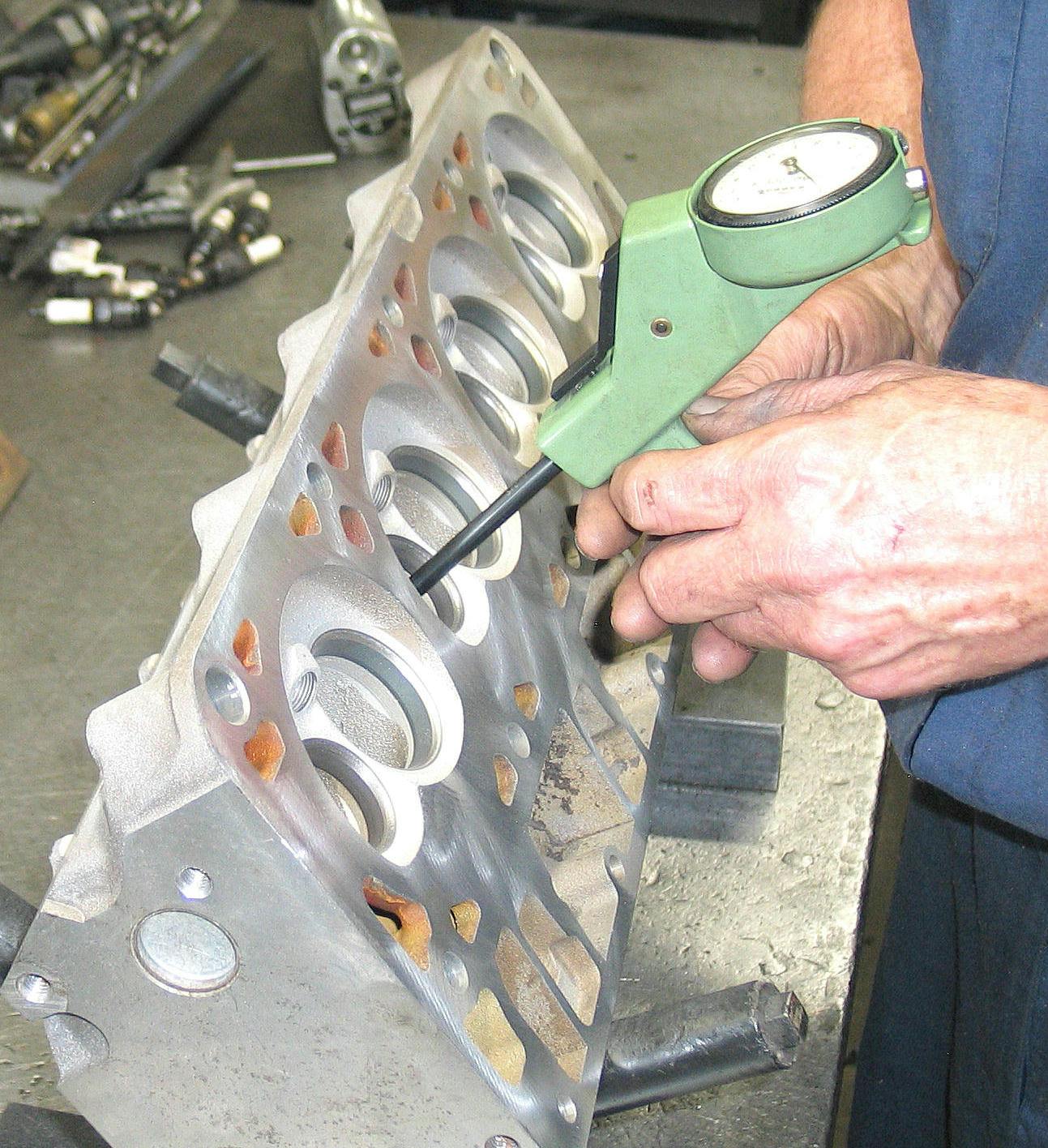 Using a small bore gauge to measure valve guide wear.