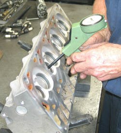 Using a small bore gauge to measure valve guide wear. Using a small bore gauge to measure valve guide wear.