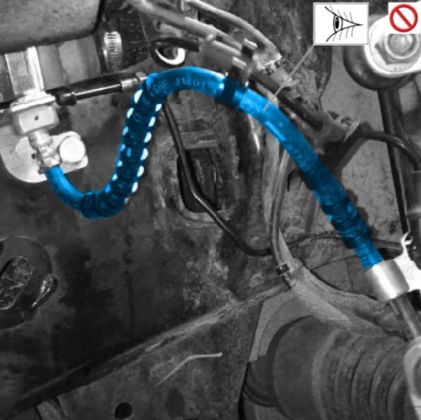 Example of incorrectly routed hose. This hose did not travel downward from the frame side and bent out prematurely toward the wheel area.