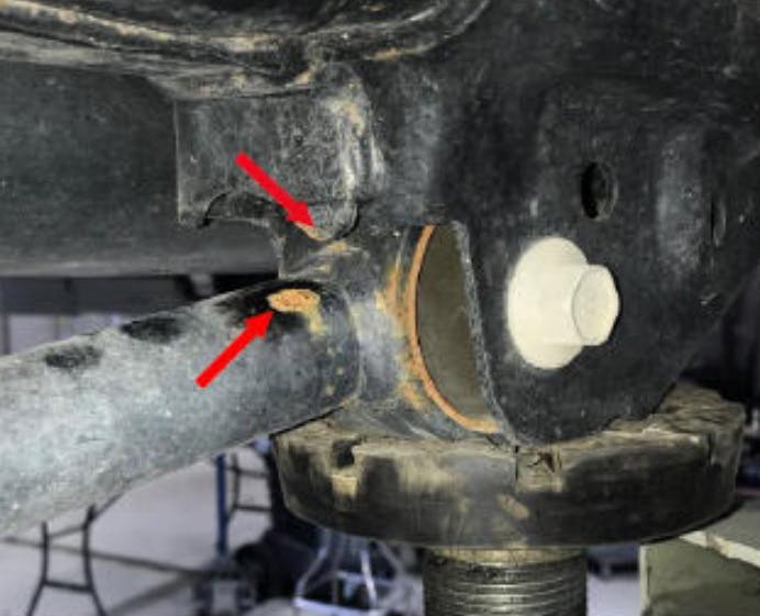 Inspect the passenger side lower control arm to see if the arm has been contacting the support bracket.