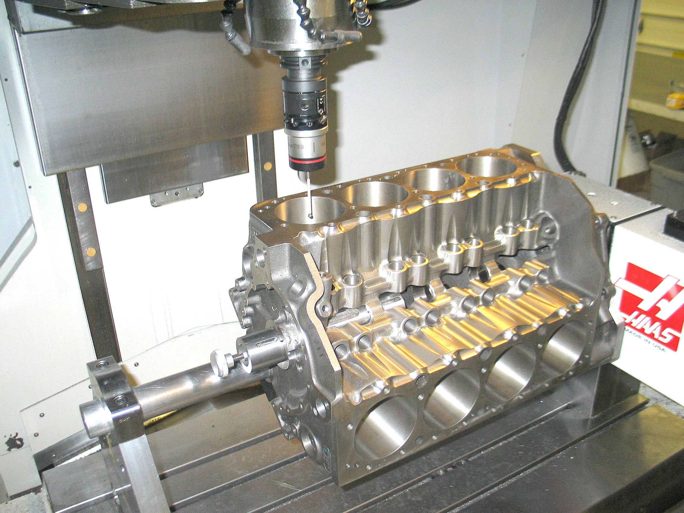 Boring a true (round) and centered hole per blueprint specifications is achieved by either using specialty fixtures or via a CNC machine that creates a true bore centerline. Here a CNC machine probe locates the bore in preparation for boring. The CNC program locates the exact bore centerline referencing crankshaft journal location.