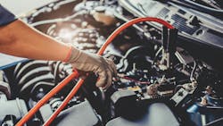 a person puts jumper cables on a car battery a person puts jumper cables on a car battery