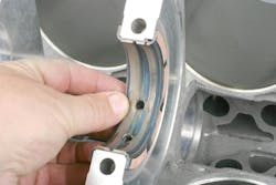 Position each main bearing in the block saddles with the bearing ends protruding by the same amount at each end, and verify that the oil holes in the bearings align with the oil feed holes in the saddles. If a slight misalignment is found, you can carefully elongate the hole in the bearing, being careful to remove any burrs. Position each main bearing in the block saddles with the bearing ends protruding by the same amount at each end, and verify that the oil holes in the bearings align with the oil feed holes in the saddles. If a slight misalignment is found, you can carefully elongate the hole in the bearing, being careful to remove any burrs.