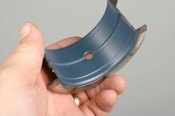 Anti-friction coating is always a good option for main and rod bearings. This coating not only promotes oil cling, but serves as an anti-friction protective layer in order to prevent bearing damage during cold starts and in brief instances of oil starvation. It is not necessary to have a moly coating applied to the front and rear faces of a main thrust bearing’s thrust surfaces, since it’s common for engine builders to sometimes fine-tune thrust clearance by filing a thrust face. An upper main thrust bearing shell is shown here. Anti-friction coating is always a good option for main and rod bearings. This coating not only promotes oil cling, but serves as an anti-friction protective layer in order to prevent bearing damage during cold starts and in brief instances of oil starvation. It is not necessary to have a moly coating applied to the front and rear faces of a main thrust bearing’s thrust surfaces, since it’s common for engine builders to sometimes fine-tune thrust clearance by filing a thrust face. An upper main thrust bearing shell is shown here.