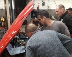 Fig. 4: Scheduling time to experiment with new-to-you tools and testing techniques (on known-good vehicles) is not only crucial to growth but also fun! Here, I’m with a group of my mates in the UK, having a great time experimenting on an engine you will likely never see in the United States. Fig. 4: Scheduling time to experiment with new-to-you tools and testing techniques (on known-good vehicles) is not only crucial to growth but also fun! Here, I’m with a group of my mates in the UK, having a great time experimenting on an engine you will likely never see in the United States.