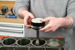 With the rings oriented in the desired clock positions, apply clean oil to piston skirts and rings and slip the piston and rod into the ring compressor, allowing the piston skirts to be exposed past the bottom of the tool. In preparation for piston/rod insertion, rotate the crankshaft to place the intended rod journal near bottom-dead-center. With the rings oriented in the desired clock positions, apply clean oil to piston skirts and rings and slip the piston and rod into the ring compressor, allowing the piston skirts to be exposed past the bottom of the tool. In preparation for piston/rod insertion, rotate the crankshaft to place the intended rod journal near bottom-dead-center.