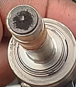 This shows a Honda GDI injector with carbon accumulation on the nozzle tip. Deposits like these can distort spray patterns, reduce fuel atomization, and contribute to misfires, fuel trim issues, and drivability complaints. This shows a Honda GDI injector with carbon accumulation on the nozzle tip. Deposits like these can distort spray patterns, reduce fuel atomization, and contribute to misfires, fuel trim issues, and drivability complaints.