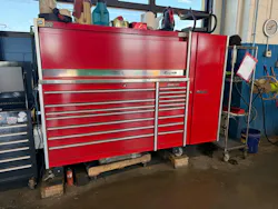 A technician's personal tool storage in a working service bay: roll cab, hutch, and side locker. In most shops, everything pictured is purchased and financed by the employee, not the business.